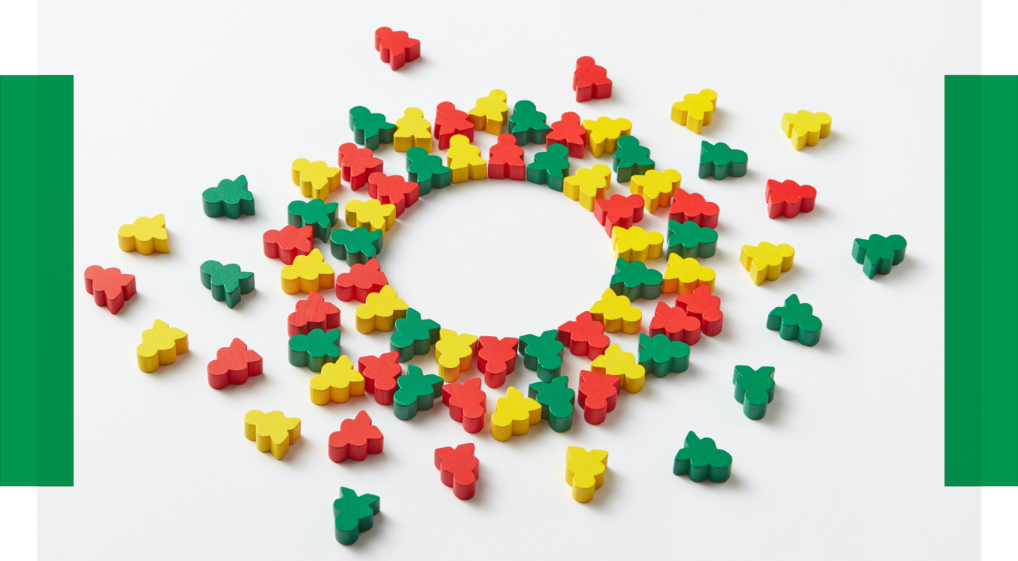 Peer-Mentoring mit Gleichgesinnten Buntes Spielzeug, das aussieht wie kleine Personen, liegt im Kreis beieinander