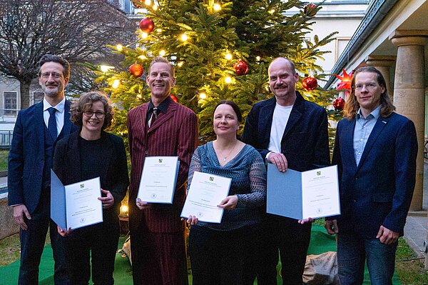 Berufungen 3.12.2025 Gruppe von sechs Personen steht vor großem Weihnachtsbaum