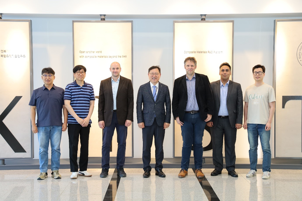 Gruppenfoto von Prof. Böhm und seinem Team mit Wissenschaftlerinnen und Wissenschaftlern, alle lächeln in die Kamera, Innenaufnahme, Logo des KIST im Hintergrund