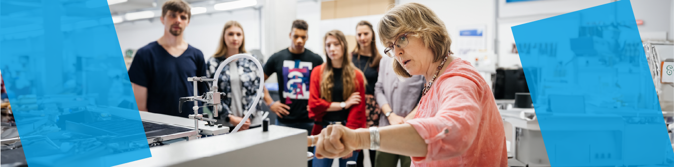 Eine Professorin erklärt interessierten Studierenden einen Druckvorgang.